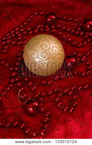 Christmas Decorations On A Red Background Accessories. Gold Ball Toy With Bright Lace.