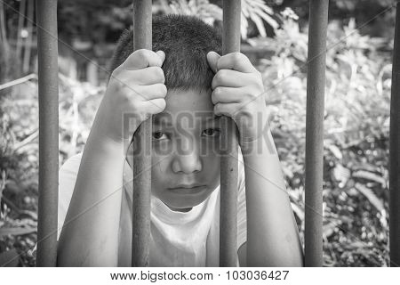 An Asian child behind bars