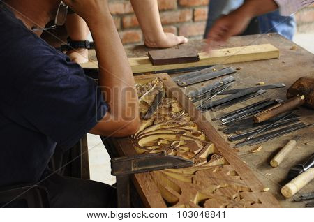 Skilled craftsman doing wood carving using traditional method