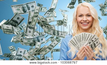 business, money, finance, people and banking concept - smiling businesswoman with dollar cash money over blue background