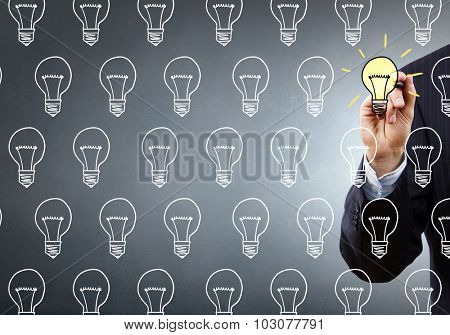 Close up of hand darwing light bulb with marker