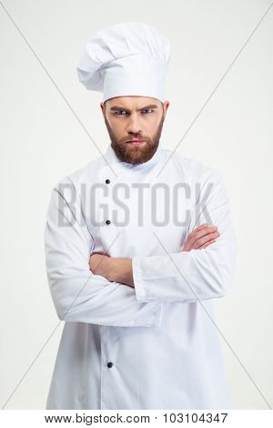 Portrait of angry male chef cook standing with arms folded isolated on a white background