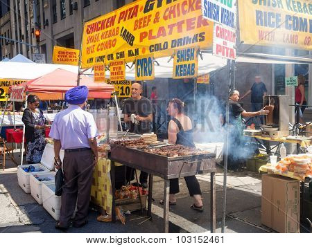 NEW YORK,USA - AUGUST 15,2015 : Street kiosk selling ethnic food at a street fair next to the Rockefeller Center in Manhattan