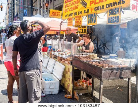 NEW YORK,USA - AUGUST 15,2015 : Street kiosk selling ethnic food at a street fair next to the Rockefeller Center in Manhattan