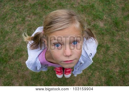 Child Girl Face From Above Perspective Shot Outside On Grass