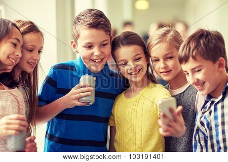 education, elementary school, drinks, children and people concept - group of school kids with smartphone and soda cans taking selfie in corridor