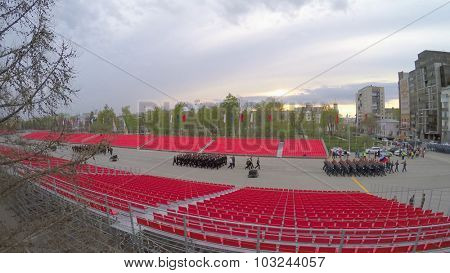 SAMARA - MAY 06, 2015: Rows of soldiers march between empty tribunes at spring evening. Aerial view video frame