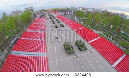 SAMARA - MAY 06, 2015: Military hardware moves along empty tribunes during parade rehearsal at spring evening. Aerial view video frame