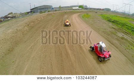 SAMARA - MAY 24, 2015: Three small racing cars ride by ground track at spring sunny day. Aerial view video frame