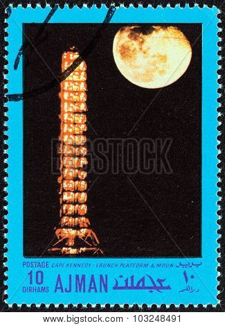AJMAN EMIRATE - CIRCA 1970: Stamp shows Cape Kennedy, launch platform and moon