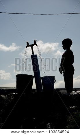 Silhouette of child getting water