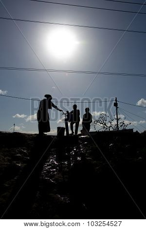Silhouette of family getting water