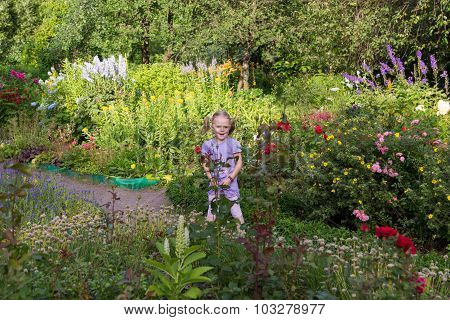 Cheerful Little Girl Among Flowers In Park