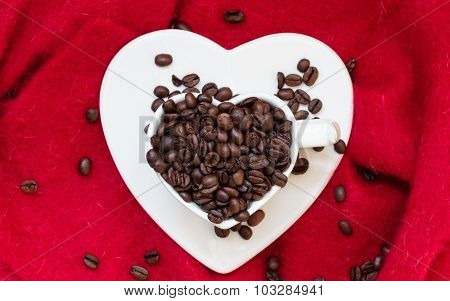 Heart Shaped Cup With Coffee Beans On Red