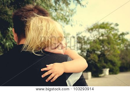 small child hugs dad. Toned image