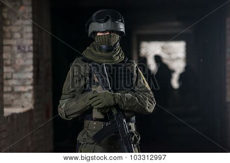 Fully equipped military men with automatic weapons playing airsoft strikeball