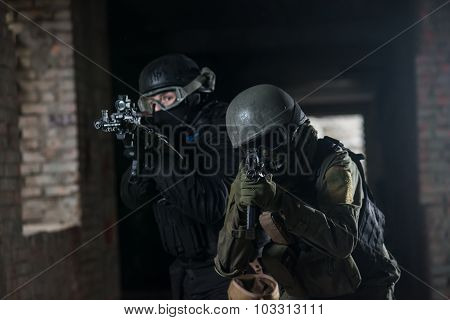 Fully equipped military men with automatic weapons playing airsoft strikeball