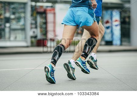 two athletes running through streets of city