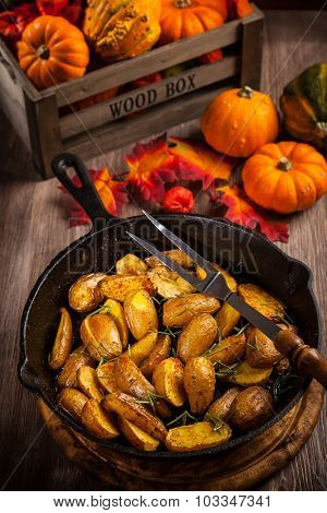 Rustic baked potatoes with herbs and pumpkins