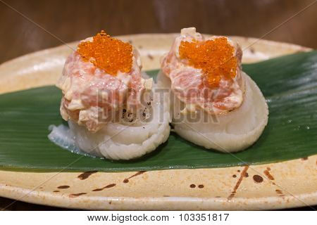 Engawa roll with salmon salad on top