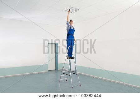 Electrician Installing Ceiling Light