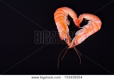 Two shrimps forming a heart isolated in a black background