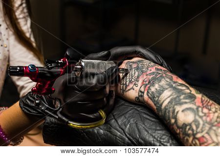 Tattooist showing process of making a tattoo