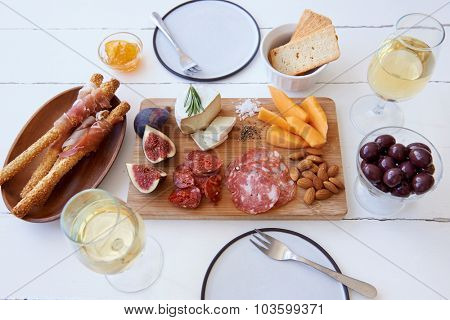 Cheese and cured meat charcuterie selection with fresh fig, rockmelon and almonds