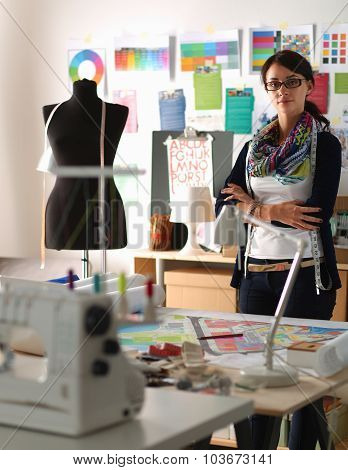 Beautiful fashion designer standing in studio