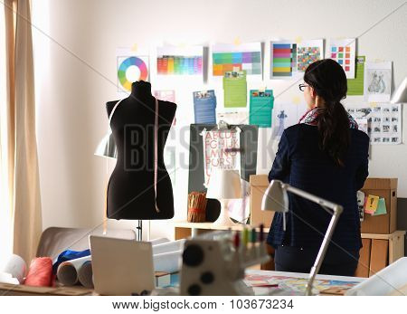Beautiful fashion designer standing in studio