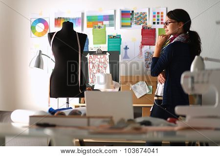 Beautiful fashion designer standing in studio