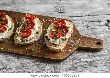 Sandwich With Goat Cheese, Sun-dried Tomatoes And Thyme, Served On The Board At A Bright Wooden Surf