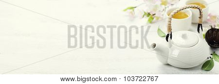 Chinese Tea Set  and sakura branch on bamboo mat