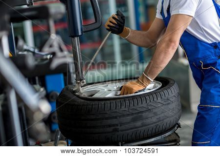 engineer  balancing  car wheel on balancer in workshop