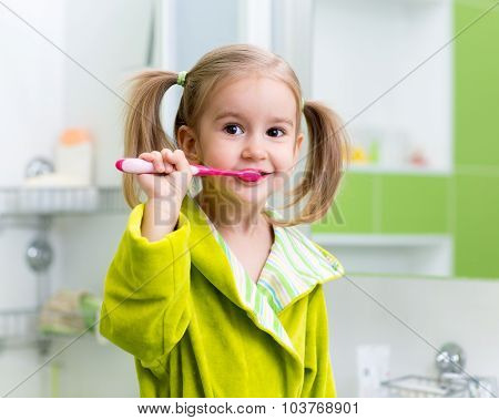 Little girl brushing teeth in bath