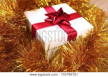 New Year gift on a golden tinsel background boly
