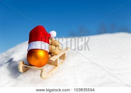 Closeup Little Sledge With A Christmas Ball In The Snow