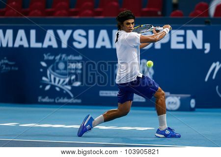 KUALA LUMPUR, MALAYSIA - SEPTEMBER 26, 2015: Syed Mohd Agil of Malaysia plays a backhand shot in his qualifying match in the Malaysian Open 2015 Tennis tournament held at the Putra Stadium, Malaysia.