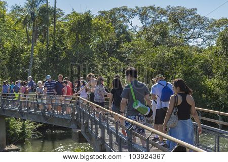 People Crossing A Bridge At Iguazu Park In Argentina