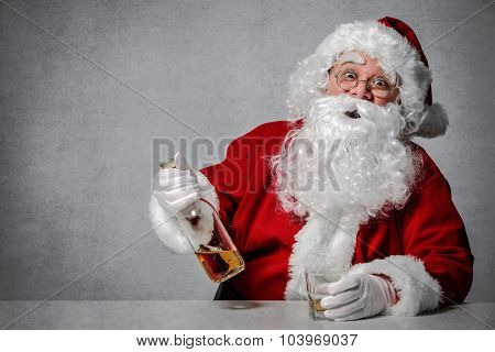 Santa Claus with a bottle of whisky enjoying a drink and taking a rest