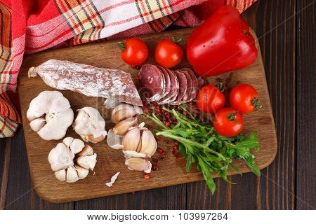 Salami On Cutting Board On Wooden Table