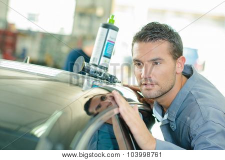 Mechanic polishing a car