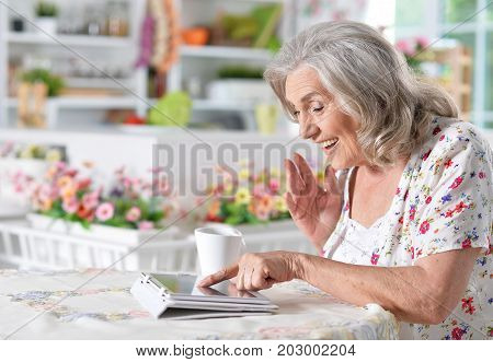 Portrait of a happy senior woman using digital tablet