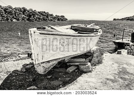 Old fishing boat with cracked white paint Solta island Croatia. Travel destination. Mediterranean scene. Black and white photo.