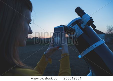 Photographing the Moon through a telescope with cellphone.