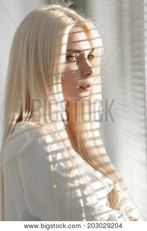 Close-up of a pensive young business woman looking out the windo