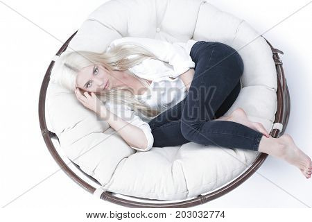 Closeup of a beautiful sad young woman sitting in a large comfor