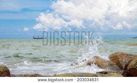 Sea wave with rock at sand beach with high speed shutter.