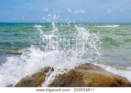 Sea wave with rock at sand beach with high speed shutter.