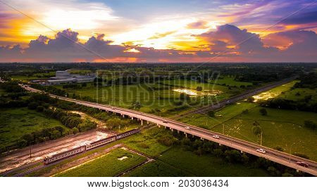 Aerial Photo Countryside Road Bridge Over Railway The train is running through the bridge and Golden Hour Sky Beautiful Landscape Drone View